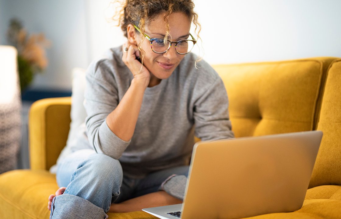 woman sitting on the couch looking at her laptop
